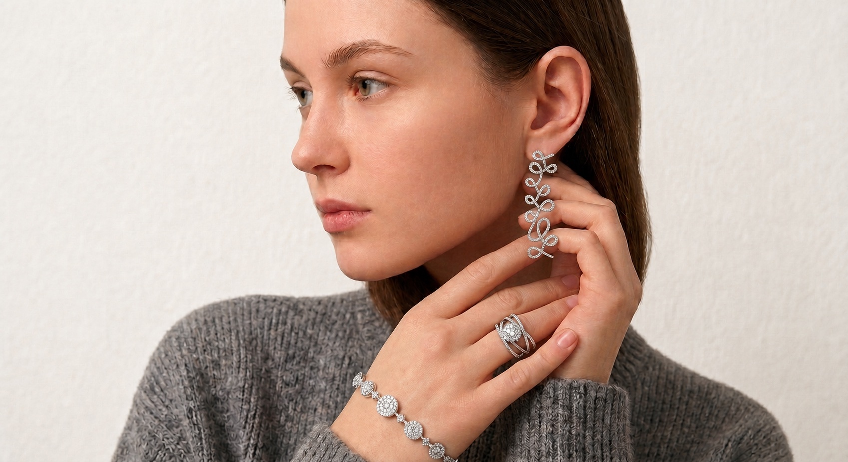 Model wearing ThienPo diamond loop earrings, ring, and bracelet
